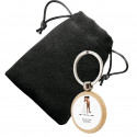 Chaveiro circular de madeira personalizado com adesivo de casamento e apresentado em bolsa de camurça