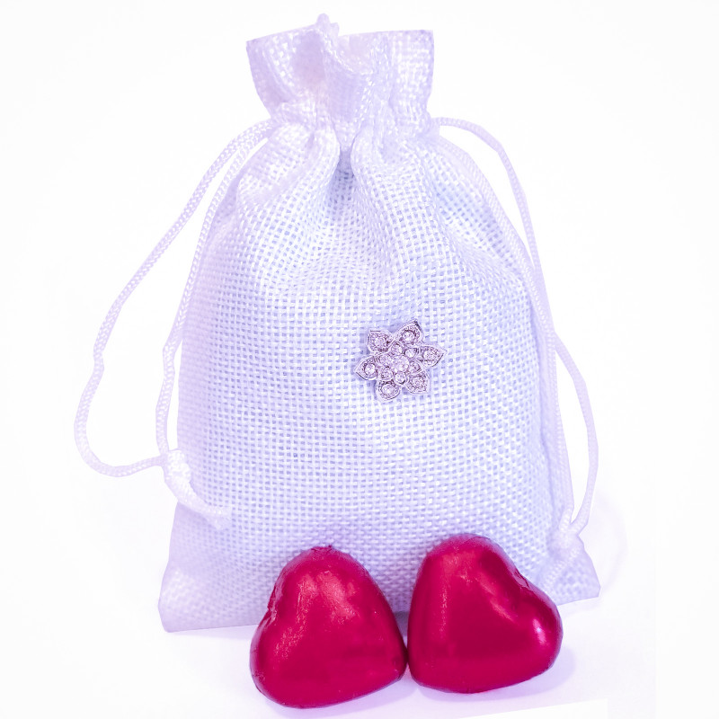 Alfinete de noiva com decoração em bolsa branca e chocolates em formato de coração