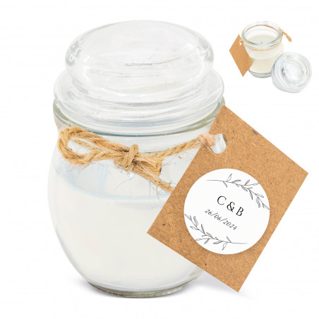Vela em um frasco de vidro com tampa e um cartão pendurado com um adesivo personalizado com detalhes do casamento.