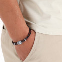 Pulseira de couro e adornos prateados em envelope preto com adesivo personalizado de iniciais para eventos